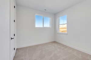 Unfurnished bedroom featuring light colored carpet