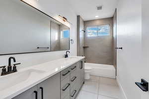 Full bathroom with toilet, tile patterned flooring, tiled shower / bath combo, and vanity