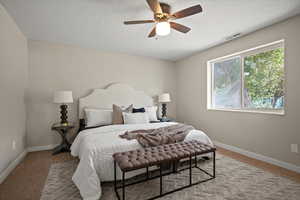 Bedroom with a textured ceiling, ceiling fan, and carpet flooring