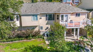 Back of house featuring a wooden deck and a patio area