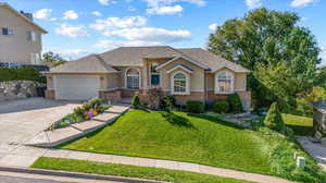 View of front facade featuring a front yard and a garage