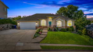 View of front of house with a garage and a yard