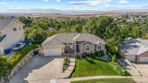 View of front facade featuring a front lawn, a mountain view, and a garage