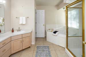 Master Bathroom featuring tile patterned floors, vanity, and shower with separate bathtub