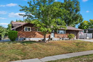 View of front facade featuring a garage and a front lawn