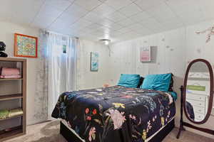 Bedroom with carpet flooring and wooden walls