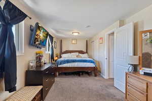 Bedroom with a textured ceiling and light colored carpet