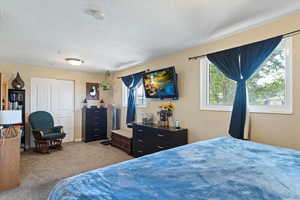 Bedroom featuring a textured ceiling and light colored carpet