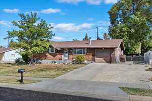 Ranch-style house featuring a garage and a front yard