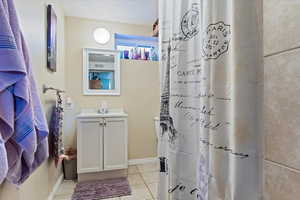 Bathroom with tile patterned floors, vanity, and a textured ceiling