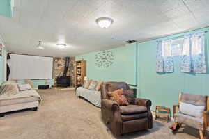 Living room with carpet flooring and a wood stove