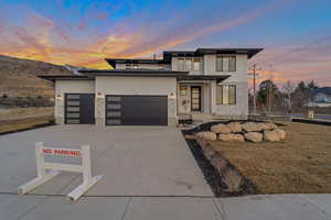 Prairie-style home featuring a garage and a lawn