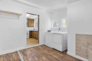 Laundry area with dark wood-type flooring and washer and clothes dryer