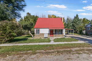 View of front of property featuring a carport and a front lawn