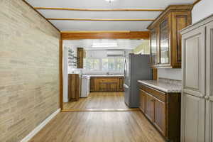 Kitchen featuring an AC wall unit, brick wall, white range with electric cooktop, and light wood-type flooring