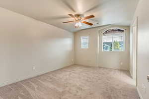 Primary bedroom with ceiling fan and natural light