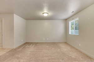 Carpeted spare room featuring a textured ceiling