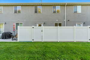 Rear view of property with a patio area and a lawn