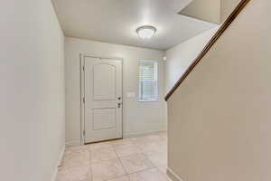 Foyer featuring light tile patterned floors and a textured ceiling