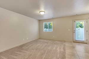 Empty room featuring a textured ceiling and light colored carpet