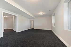 Carpeted empty room with a textured ceiling