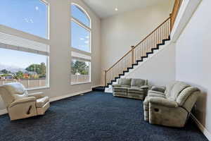 Living room featuring a towering ceiling and carpet