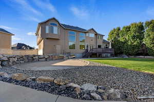 Rear view of property featuring a yard, a patio area, and a deck