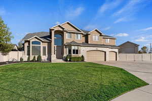 View of front of home with a front yard and a garage