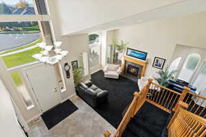 Foyer featuring a premium fireplace, a towering ceiling, and an inviting chandelier