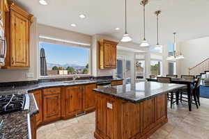 Kitchen with a mountain view, decorative light fixtures, sink, and a center island