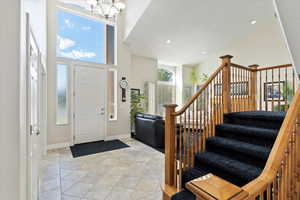 Foyer entrance featuring a notable chandelier and a towering ceiling