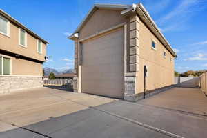 View of property exterior with a mountain view and a garage