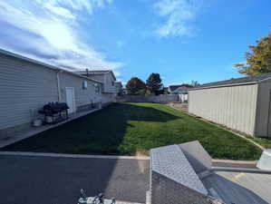 View of yard with a storage unit and a patio