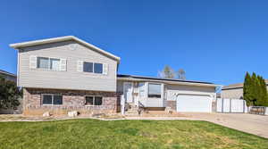 Split level home featuring a front yard and a garage