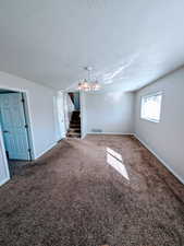 Unfurnished room with a textured ceiling and dark carpet