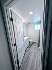 Bathroom featuring toilet, hardwood / wood-style floors, vanity, and a shower with shower curtain