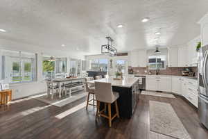 Kitchen featuring plenty of natural light, a center island, and white cabinets