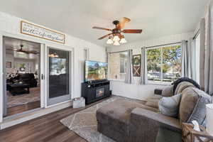 Sunroom / solarium with a fireplace and ceiling fan