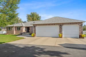 Single story home featuring a garage and a private front yard