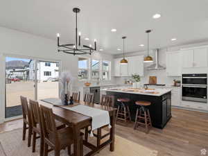 Dining room featuring hardwood / wood-style flooring, a notable chandelier, and a healthy amount of sunlight