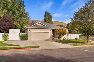 View of front of home with a mountain view, a front yard, and a garage