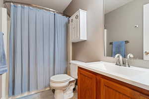 Bathroom with a shower with curtain, vanity, and toilet