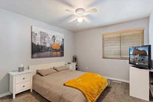 Bedroom with ceiling fan and dark carpet