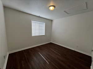 Spare room with dark wood-type flooring