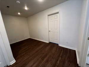 Empty room with dark hardwood / wood-style floors