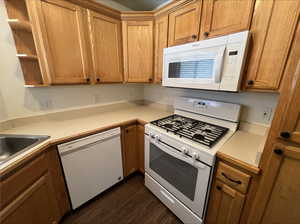 Kitchen with white appliances, sink, and dark hardwood / wood-style flooring