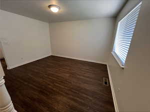 Unfurnished room with dark hardwood / wood-style flooring