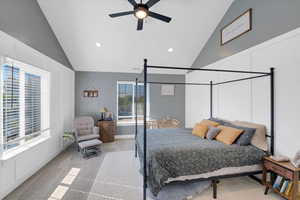 Carpeted bedroom featuring ceiling fan and high vaulted ceiling