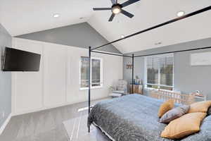 Bedroom with light carpet, ceiling fan, and vaulted ceiling