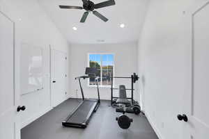 Workout area featuring ceiling fan and vaulted ceiling